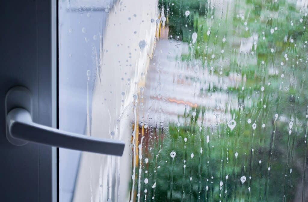 Window pane cleaning:.Close up of white window handle, glass in soapy streaks and stains